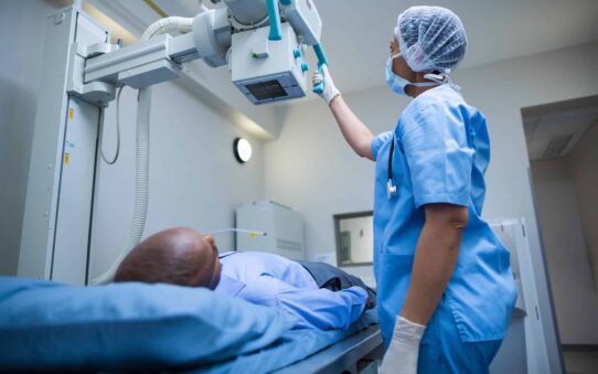 Female-doctor-sets-up-the-machine-to-x-ray-over-patient